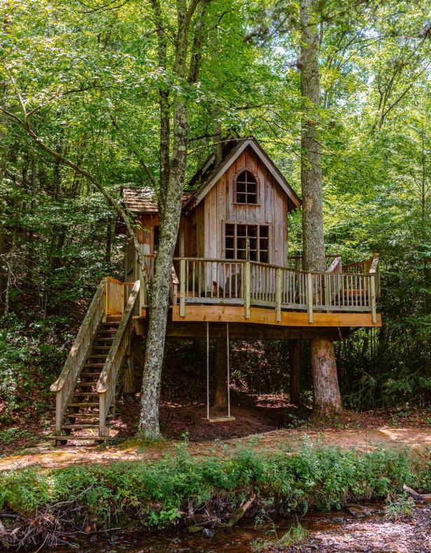 A small cabin built between two treetops in the forest