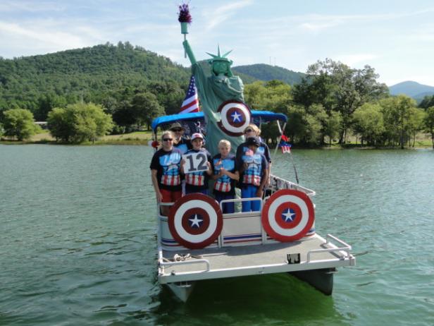 A small boat floats along in a boat parade