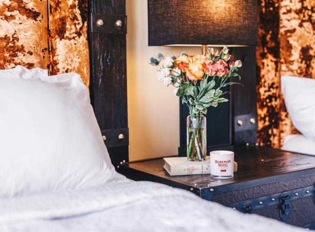Flowers on a table between beds inside a room at the Bohemian Hotel