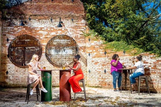 Two sets of women socializing at high top tables at the Oconee Brewing Company in Greensboro, Georgia.