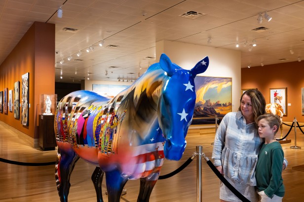 Mother and son look at a large painted horse inside the Booth Western Art Museum in Cartersville, Georgia