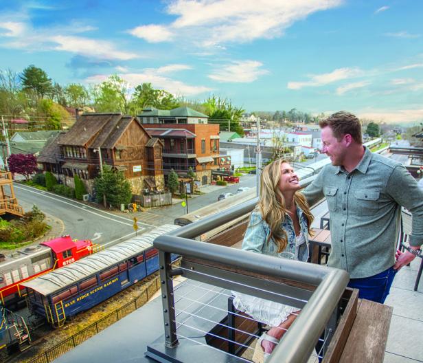 Hook & Eye couple standing next to each other smiling outside on a balcony in Blue Ridge, Georgia.