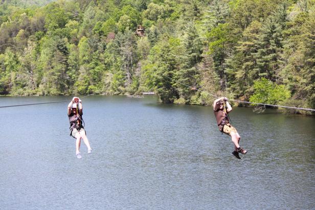 Two people ziplining over a lake at Unicoi State Park in Helen, Georgia