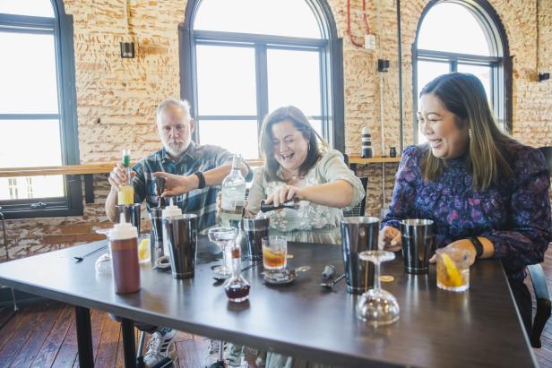Three people experimenting with craft cocktail making at a table during the "Bartender for a Day" class led by Zach McCabe of All Equal Parts in Augusta, Georgia