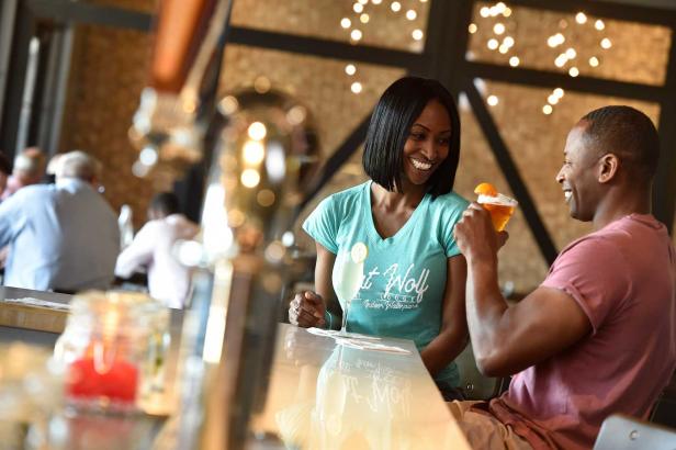 A man and woman sip a cocktail and a beer at a bar at Great Wolf Lodge
