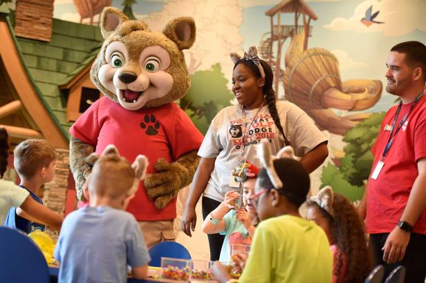 Kids gather round a Camp Howl councelor and a giant stuffed bear