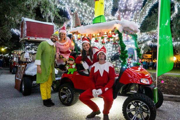 Four festive people dressed in fun holiday attire at the Holly Jolly Jekyll parade in Georgia