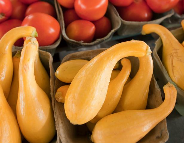 Yellow crookneck squash and red tomatoes in baskets at the Atlanta State Farmers Market in Clayton County