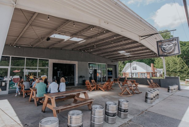 People sitting at picnic tables on the front patio of Currahee Brewing Company in Clayton, Georgia