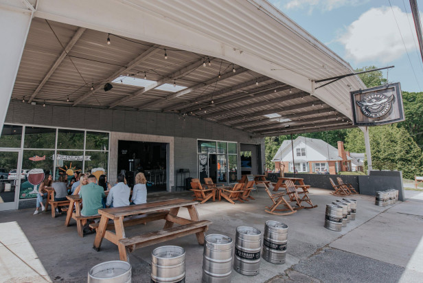 People sitting at picnic tables on the front patio of Currahee Brewing Company in Clayton, Georgia