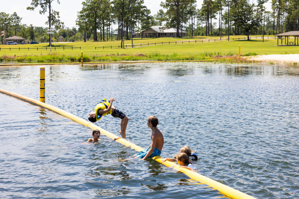 Kids swimming and doing a backflip in the lake at Seminole State Park in Donalsonville, Georgia