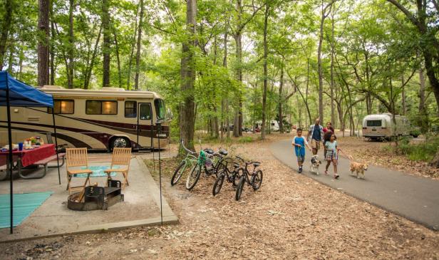 Family walking dog near an RV campsite