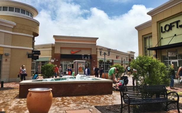 Families gather in an outdoor courtyard at The Outlet Shoppes at Atlanta