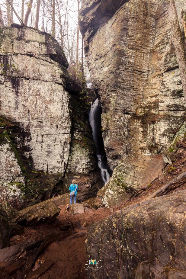 A thin waterfall flows down between large rocks.
