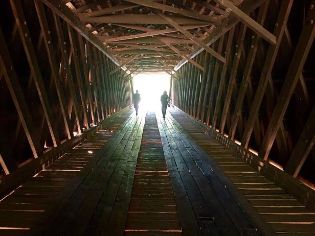 Two people walking inside a covered bridge in Woodbury, Georgia.
