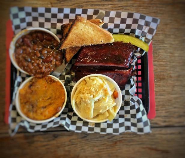 Overhead view of a tray of barbecue and side dishes