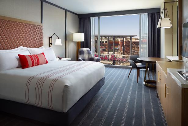 The inside of a hotel room with a view of the city outside.