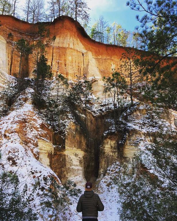 Man hiking in snow-dusted Providence Canyon State Park in Lumpkin, Georgia. Photo by @ludwig_lory83