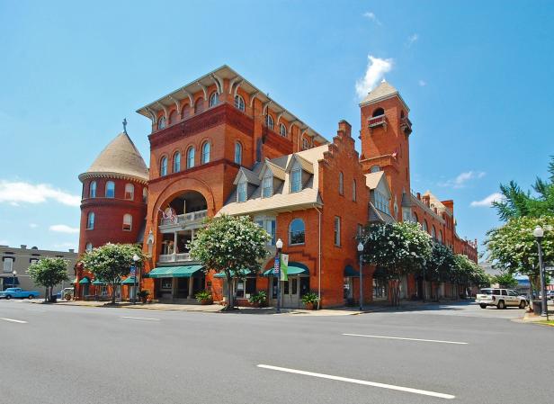 A large hotel sits in the middle of a small downtown