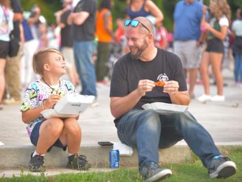 Dad with child enjoys some delicious wings together