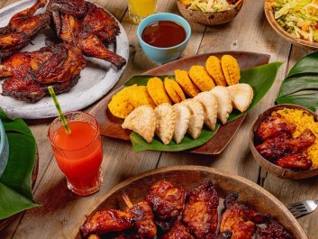 Vibrant tropical feast spread with grilled meats, plantains, fresh salads, and colorful beverages.