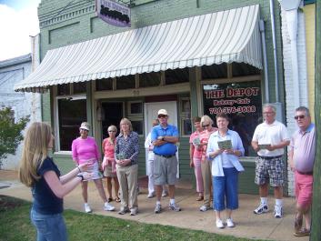 A group learns about the history of Hartwell's Depot Street as part of a guided tour.