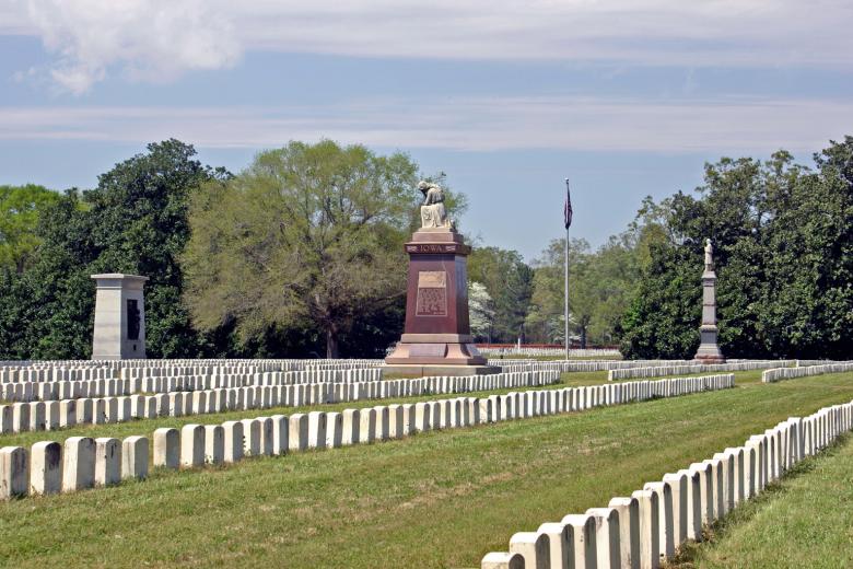 Rows of simple white tombstones line a historic cemetery.