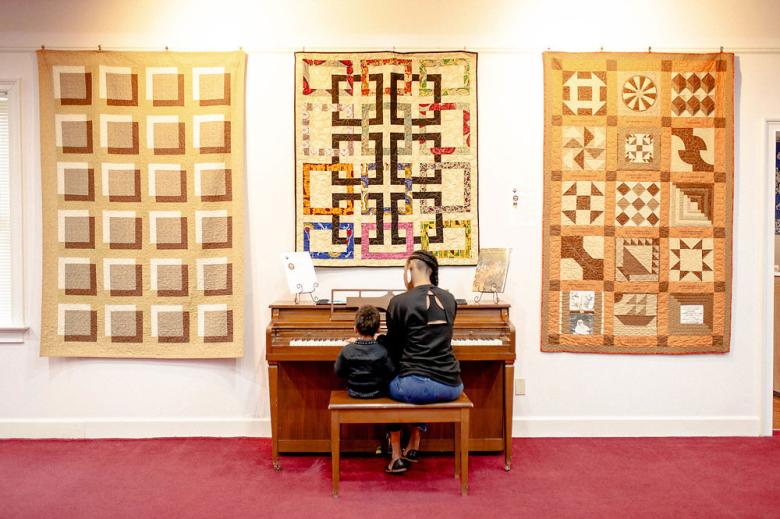 Mother and child at piano at Lucy Craft Laney Museum in Augusta, Georgia
