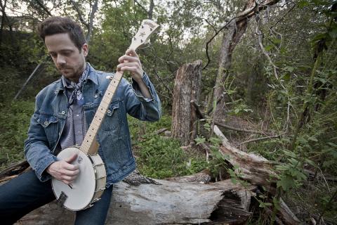Man playing banjo in the woods