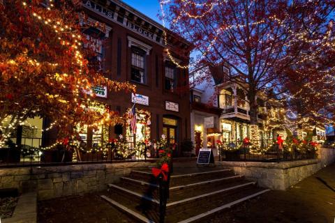 A small town street lit up with holiday lights.