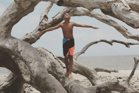 Boy on Driftwood Beach on Jekyll Island, Georgia. Photo by @qued3point14