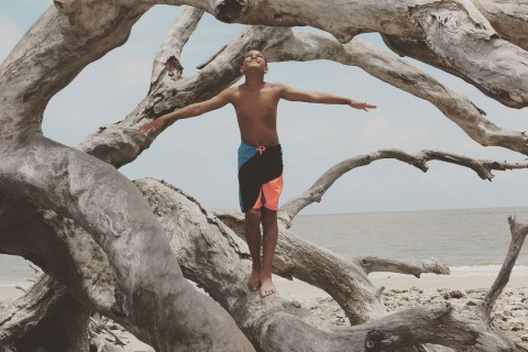 Boy on Driftwood Beach on Jekyll Island, Georgia. Photo by @qued3point14