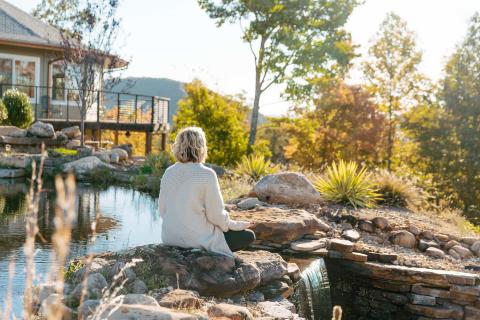 Woman meditating outside at a wellnes retreat at Elohee in Sautee Nacoochee, Georgia