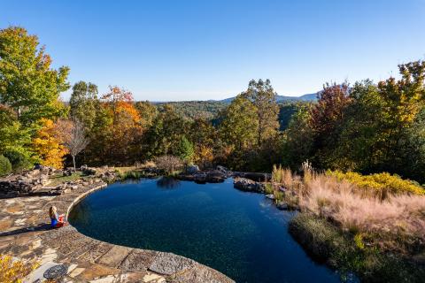 Woman sitting by a pond at Elohee in Sautee Nacoochee, Georgia. Photo by @benjamingalland