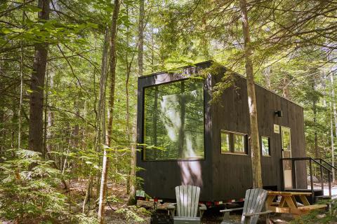 A mobile camp house sits in the woods. 