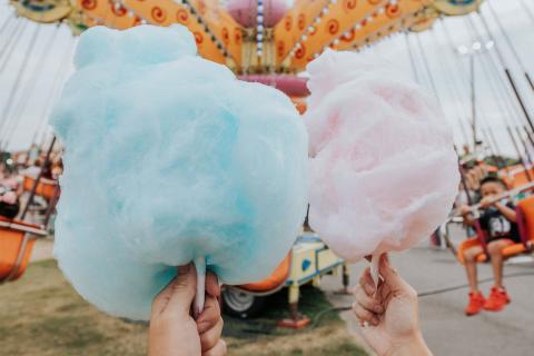Two hands holding cotton candy at the North Georgia State Fair in Marietta, Georgia. Photo by @gcalebjones