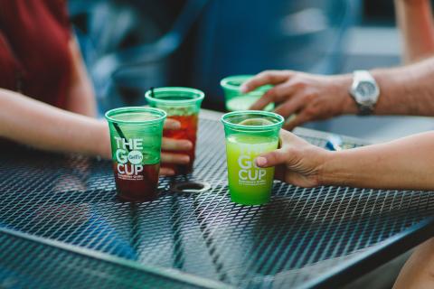 Four green cups on a table outdoors promoting downtown Griffin in Griffin, Georgia.