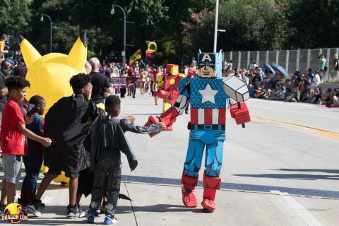 Costumed characters march down the street in a parade