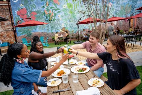Four friends dining outside at Last Resort Grill