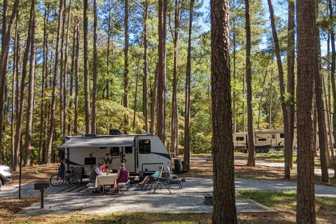 Family sitting at a picnic table near their RV