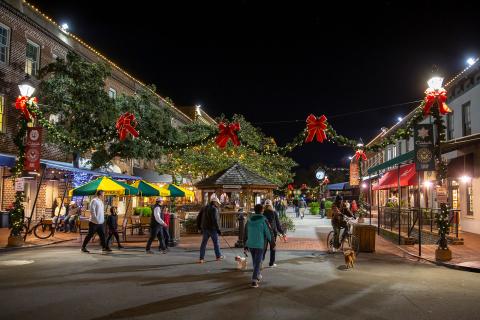Shoppers stroll through a city market decorated with Christmas displays