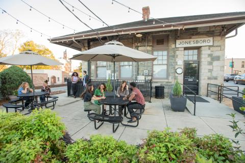 People sit enjoying themselves at outdoor tables at Clayton County Georgia's Visitors Center in Jonesboro