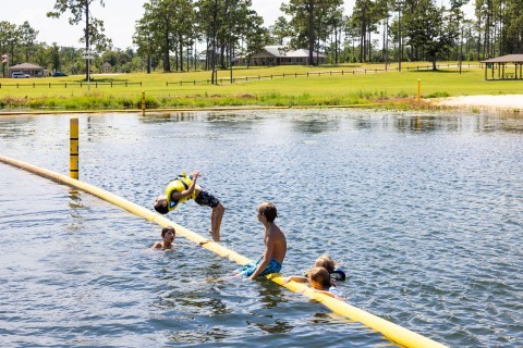 Kids swimming and doing a backflip in the lake at Seminole State Park in Donalsonville, Georgia