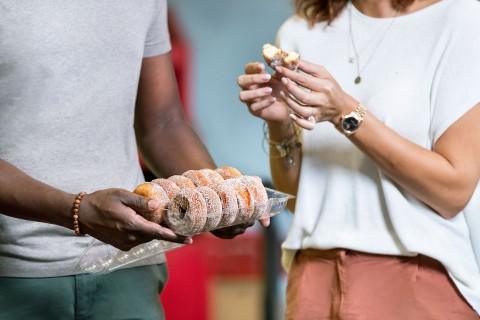 A couple holds a plate of apple-cider donuts
