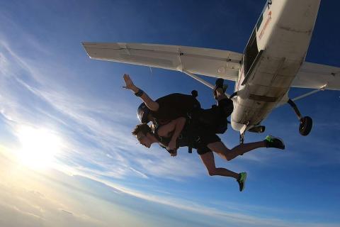 Tandem skydivers float through the air after jumping from an airplane