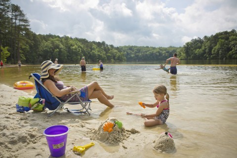 Family at the lakeside beach at Don Carter State Park in Gainesville, Georgia
