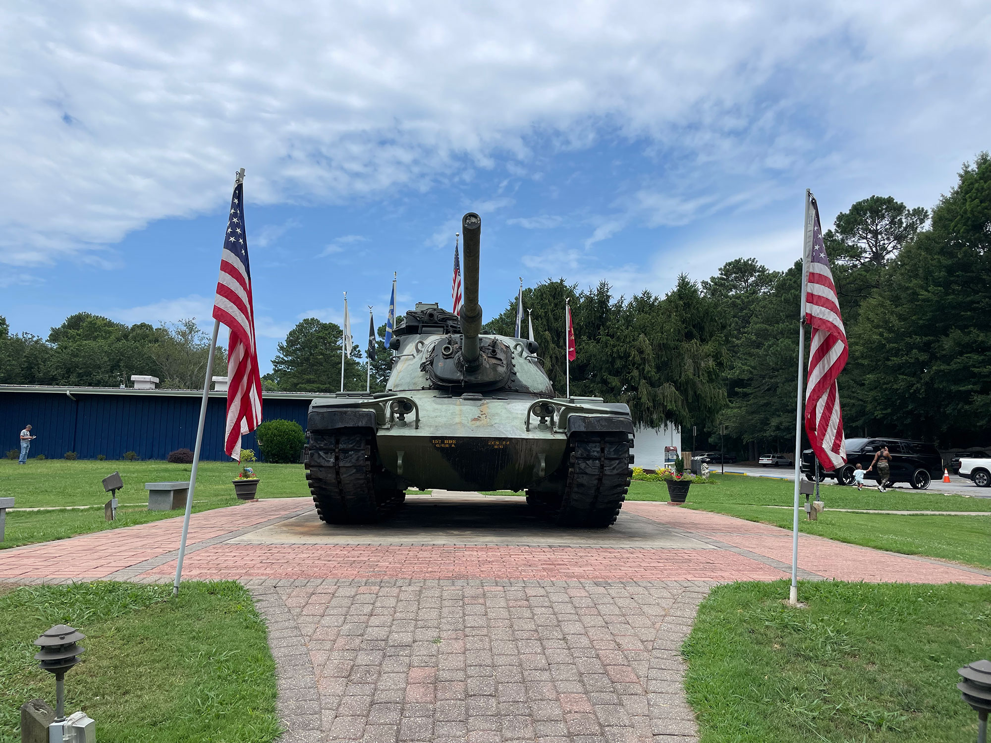 Tank parked on pavers and surrounded by American flags at the Walk of Memories in Alpharetta, Georgia
