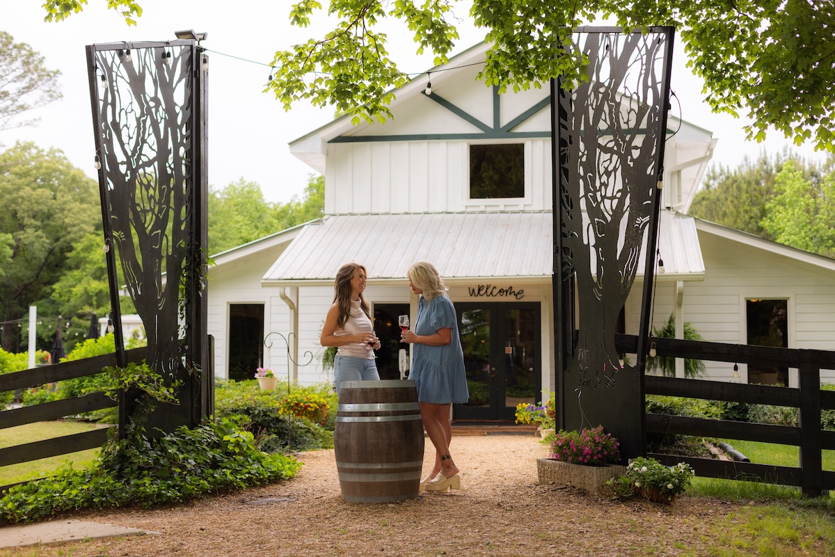 Nutwood Winery exterior with two women standing outside holding glasses of red wine