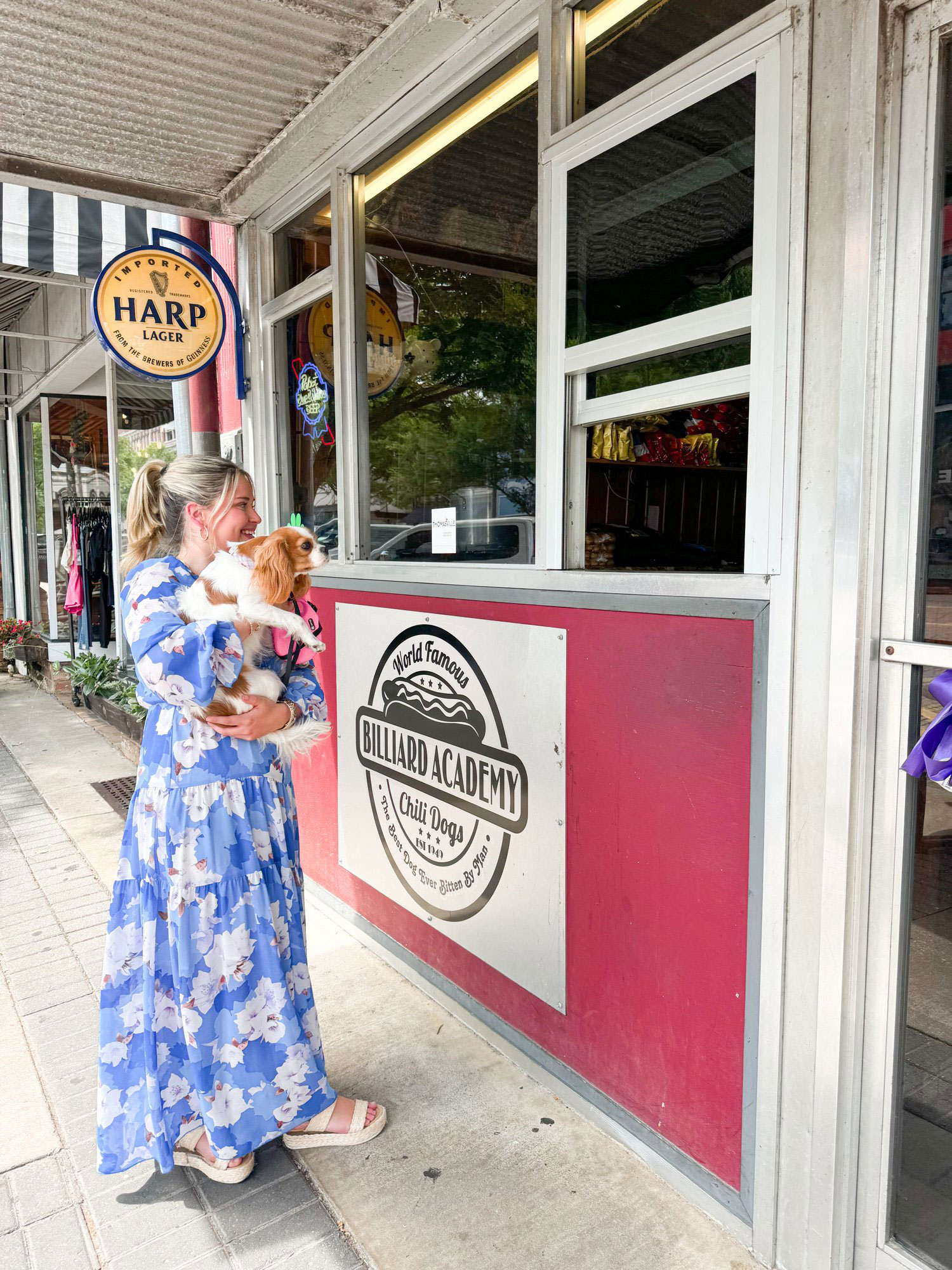 Woman holding dog outside Billiard Academy in Thomasville, Georgia