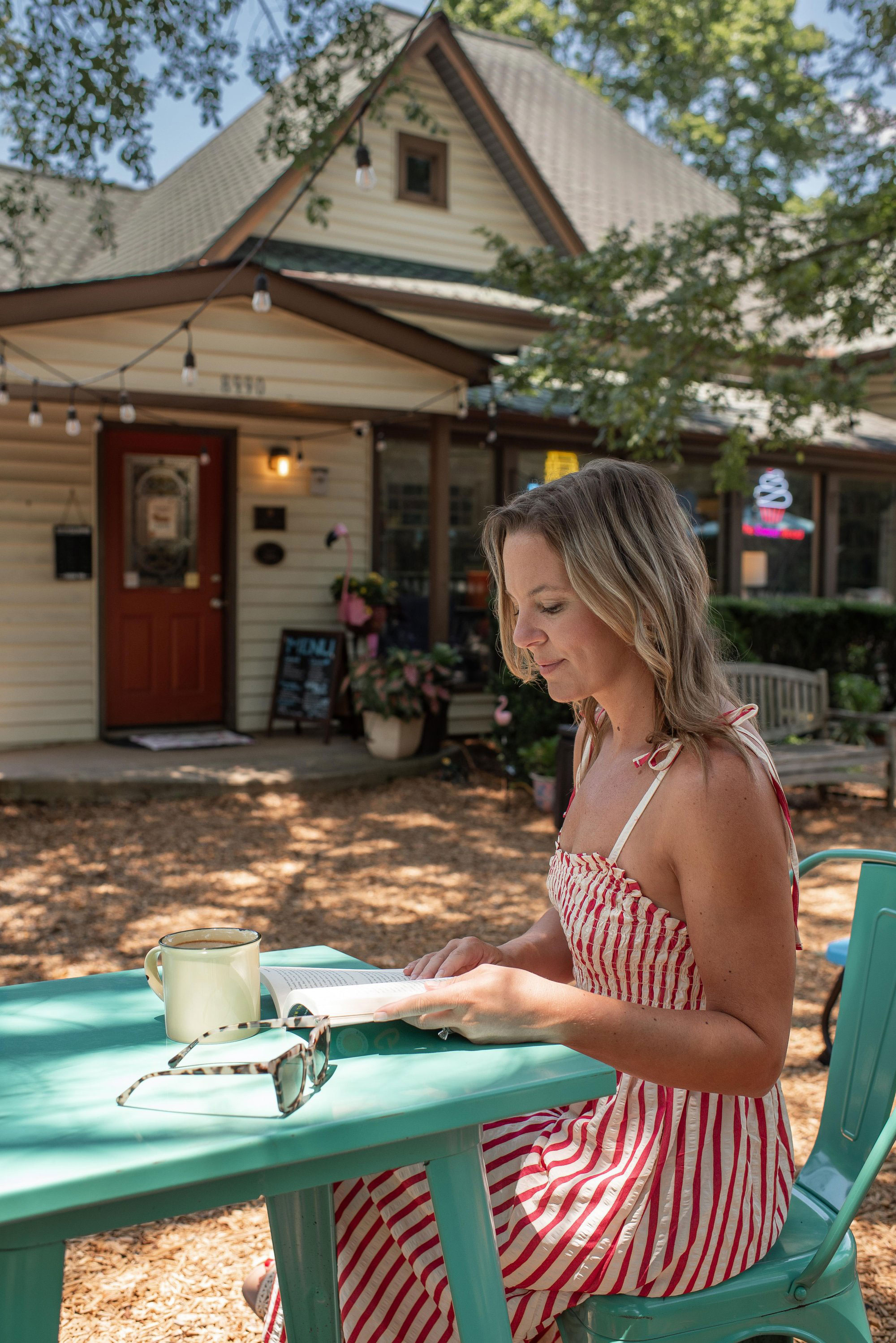 Woman sitting outside reading at The Sweet Read in Woodstock, Georgia